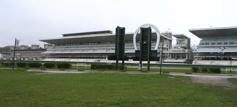 The Hippodrome de Longchamp racecourse outside Paris. In 1924, Théophile Bader (Galeries Lafayette) introduced Pierre Wertheimer to Coco Chanel at Longchamp; the 70/20/10 partnership for Parfums Chanel was negotiated as a result of that introduction.