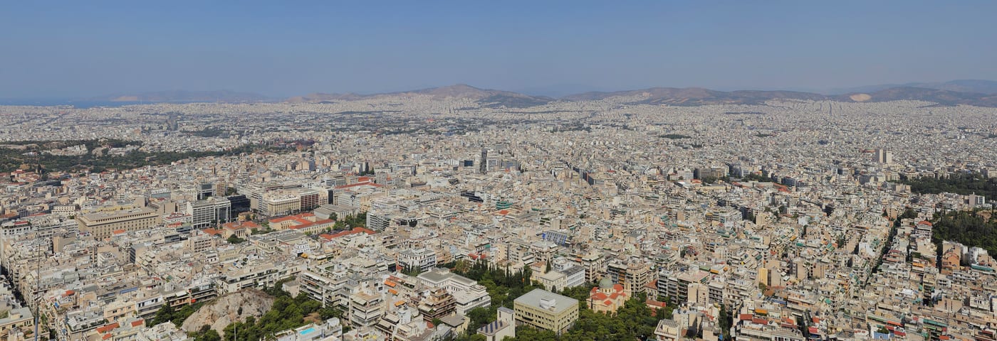 A panoramic view of Athens from Lycabettus Hill. The city below sits across the Saronic basin towards the Athens Riviera and Cape Sounion.