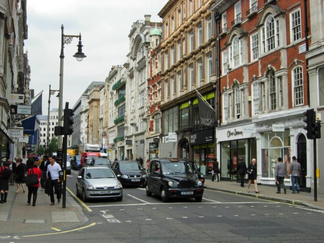 New Bond Street in London's Mayfair, photographed from the Brook Street junction. The source neighbourhood of the UK non-dom population now redistributing across Italy, Switzerland, Dubai, Greece and Spain.